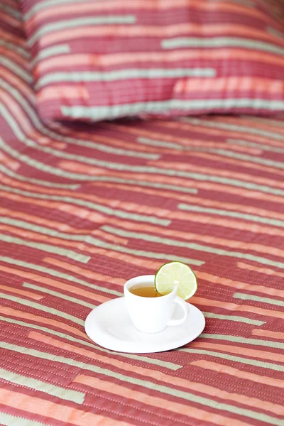 Łóżko z dwoma poduszkami, filiżankę herbaty na koc — Zdjęcie stockowe