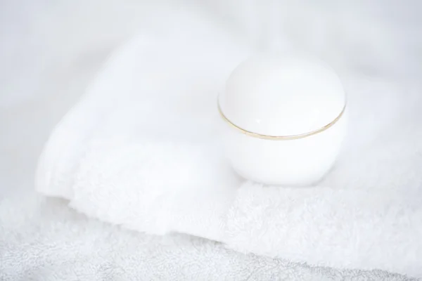Recipientes cosméticos acostados sobre una toalla blanca —  Fotos de Stock