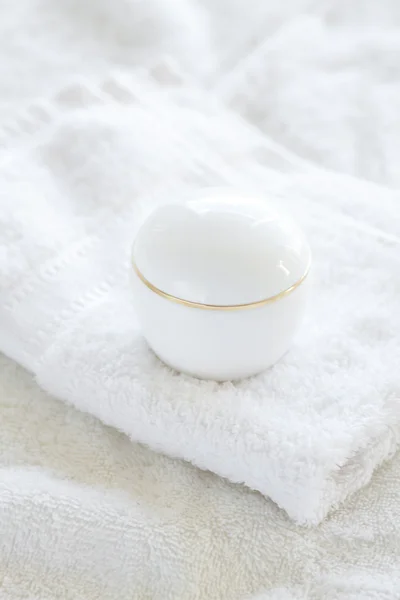 Kosmetikbehälter liegen auf weißem Handtuch — Stockfoto