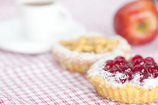 果実、リンゴ、チェック柄のファブリックにお茶と美しいケーキ — ストック写真
