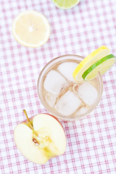 Νερό με λεμόνι και λάιμ, μήλο σε ένα ποτήρι με πάγο — Φωτογραφία Αρχείου