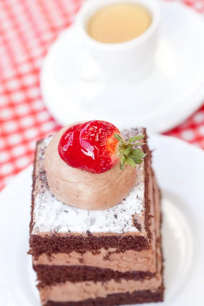 Beautiful cake with strawberry and tea on plaid fabric — Stock Photo, Image