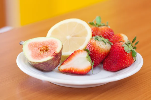 Zitrone, Feige und Erdbeeren auf einem Teller — Stockfoto