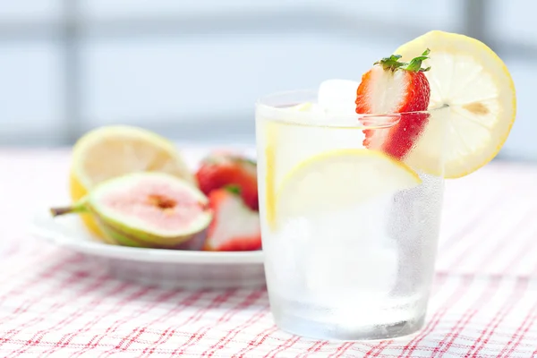 Cocktail mit Eis, Zitrone, Feige und Erdbeeren auf einem Teller — Stockfoto