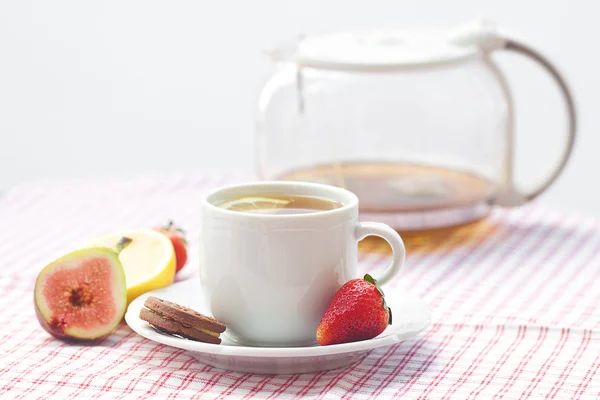 Tasse de thé, biscuit, figue et fraises sur une assiette — Photo