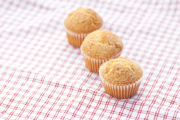 Three muffins on plaid fabric — Stock Photo, Image