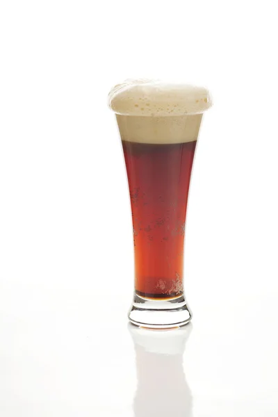 Cerveza oscura con la espuma en un vaso alto aislado en blanco —  Fotos de Stock