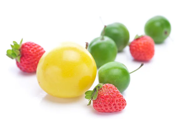 Prunes vertes et jaunes et fraises isolées sur blanc — Photo