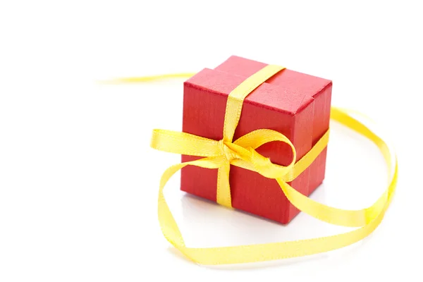 Rode geschenkdoos met een geel lint geïsoleerd op wit — Stockfoto