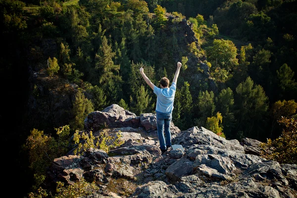 Young man standing on a rock slope — Stock Photo, Image