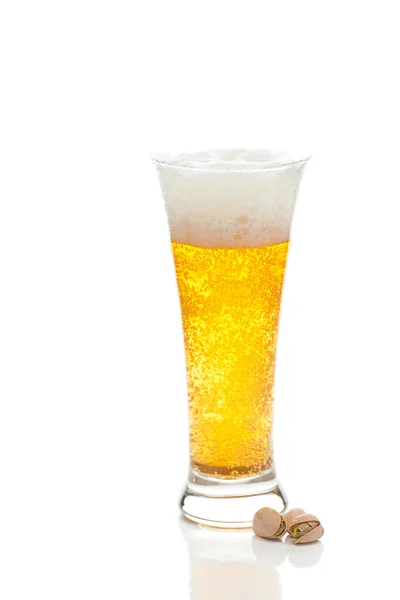 Light beer with the foam in a tall glass and pistachios isolated — Stock Photo, Image