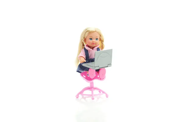 Dukke sidder på en stol med laptop isoleret på hvid - Stock-foto