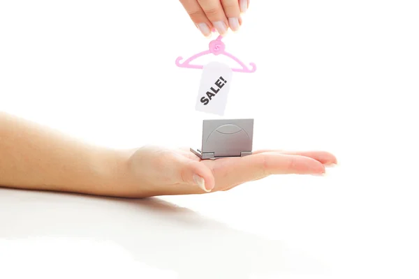 Miniatuur laptop en hanger met een prijskaartje verkoop in hand isolat — Stockfoto