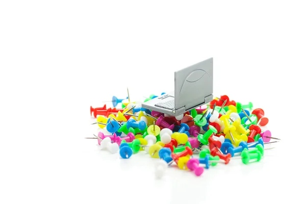 Miniatuur laptop en gekleurde pinnen geïsoleerd op wit — Stockfoto