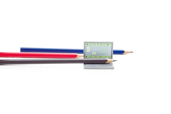 Färgpennor och miniatyr laptop isolerad på vit — Stockfoto