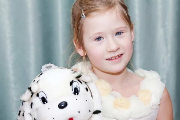 Porträtt av en vacker liten flicka med en leksak hund — Stockfoto
