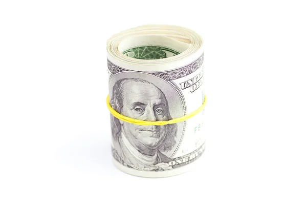 Долари загорнуті в трубку, прив'язану еластичною стрічкою ізольовані на — стокове фото