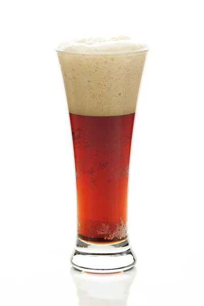 Bière foncée avec la mousse dans un grand verre isolé sur blanc — Photo