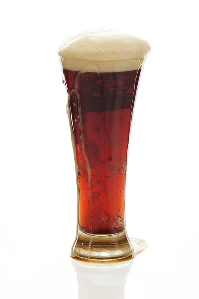 Ciemne piwo z pianką w wysokiej szklance na białym tle — Zdjęcie stockowe