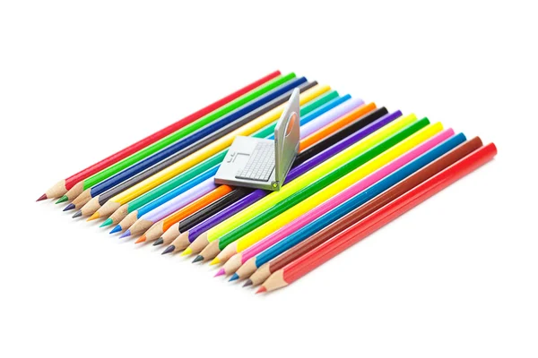 Kleurpotloden en miniatuur laptop geïsoleerd op wit — Stockfoto