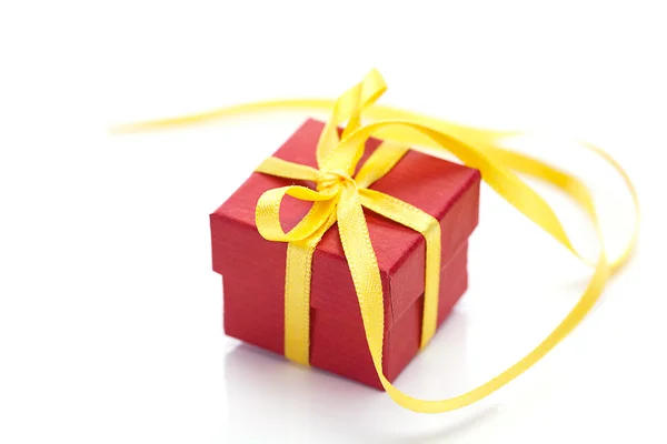 Rode geschenkdoos met een geel lint geïsoleerd op wit — Stockfoto