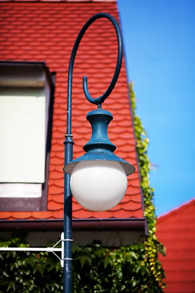 Vecchia lanterna contro il tetto e le finestre — Foto Stock