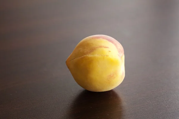 Персик лежить на дерев'яному столі — стокове фото