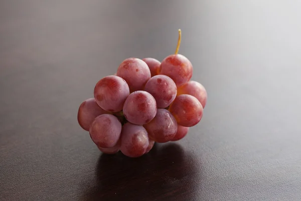 Racimo de uvas tumbadas en una mesa de madera —  Fotos de Stock