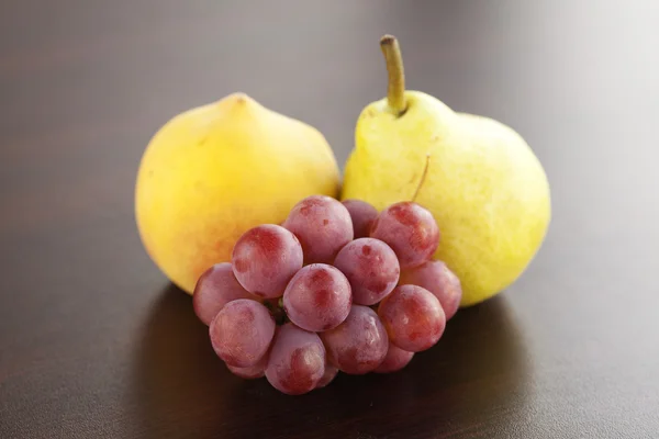 Durazno, pera y uvas tumbadas sobre una mesa de madera —  Fotos de Stock