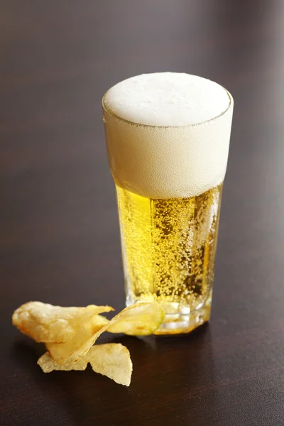 Ποτήρι ελαφριά μπίρα και μάρκες σε ένα ξύλινο τραπέζι — Φωτογραφία Αρχείου