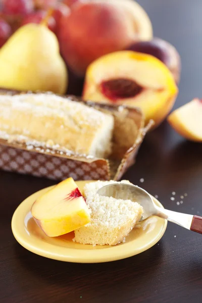 桃、 梨、 李子、 椰子蛋糕、 勺子和木制的选项卡上的葡萄 — 图库照片
