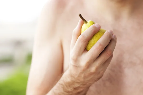 Man holding a pear in his hand — Stock Photo, Image