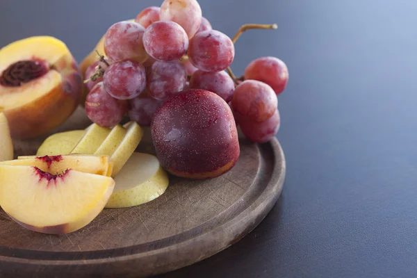 Brzoskwinia, gruszki i winogrona na pokładzie cięcia — Zdjęcie stockowe
