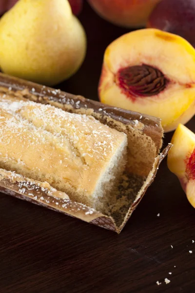 Персик, груша, слива и кокосовый торт на деревянном столе — стоковое фото