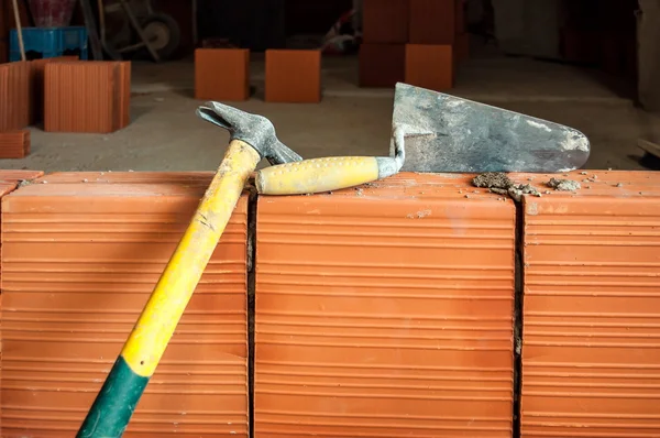 Молоток и лопатка на строительной площадке — стоковое фото
