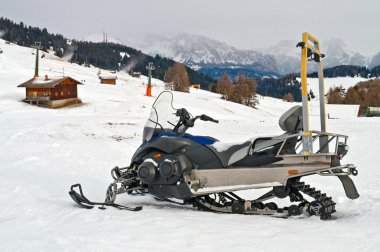 Snowmobile on alps in winter time clipart