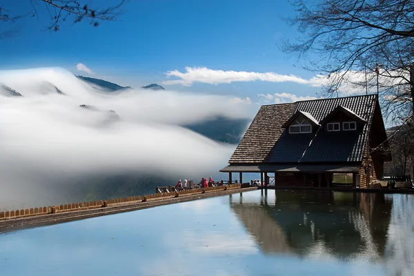 Dramatische wolken met berg met een klein huis — Stockfoto