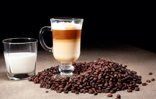 Cappuccino glass with coffee beans and glass of milk — Stock Photo, Image
