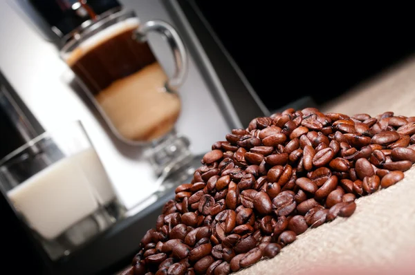Coffee beans heap, latte and coffee machine — Stock Photo, Image
