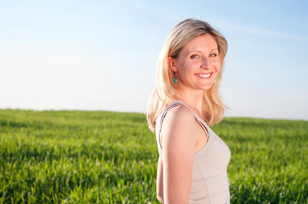 Счастливая женщина изображает в зеленом поле — стоковое фото