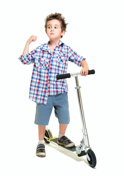 Ondeugende harige kleine jongen in korte broek en shirt met scooter — Stockfoto