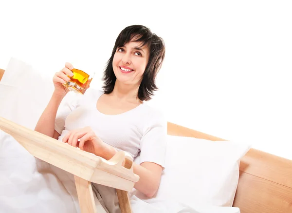 Mujer feliz en la cama con jugo de manzana —  Fotos de Stock