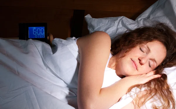 Redhead woman sleeping by the alarm clock — Stock Photo, Image