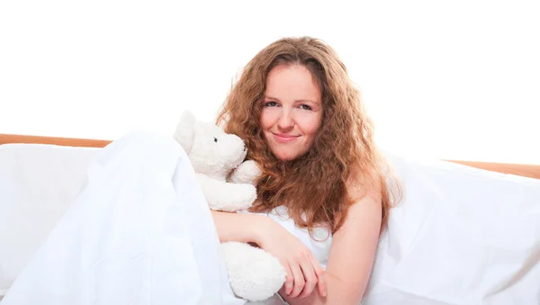 Oyuncak ayı kucaklayan yatakta kadın — Stok fotoğraf