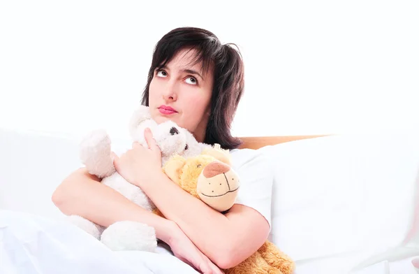 Daydreaming woman in bed with teddy bear toys — Stock Photo, Image