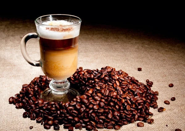 Cappuccino glass with coffee beans — Stock Photo, Image