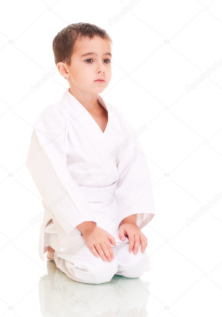 Karate boy sitting in white kimono
