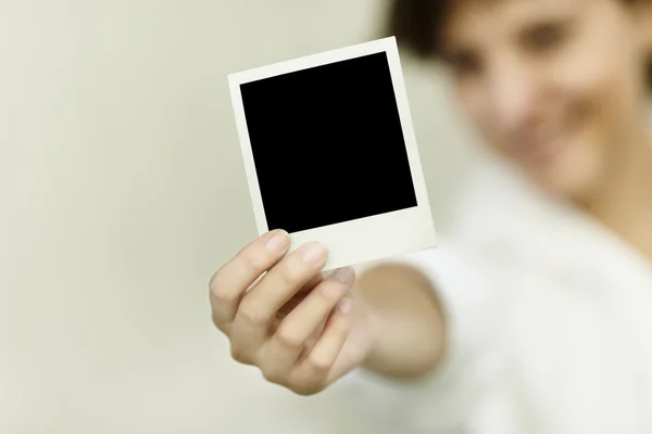 Молодая женщина держит пустое фото — стоковое фото