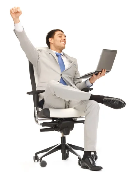Jovem empresário sentado na cadeira com laptop — Fotografia de Stock