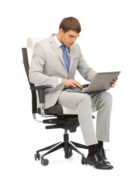 Jovem empresário sentado na cadeira com laptop — Fotografia de Stock